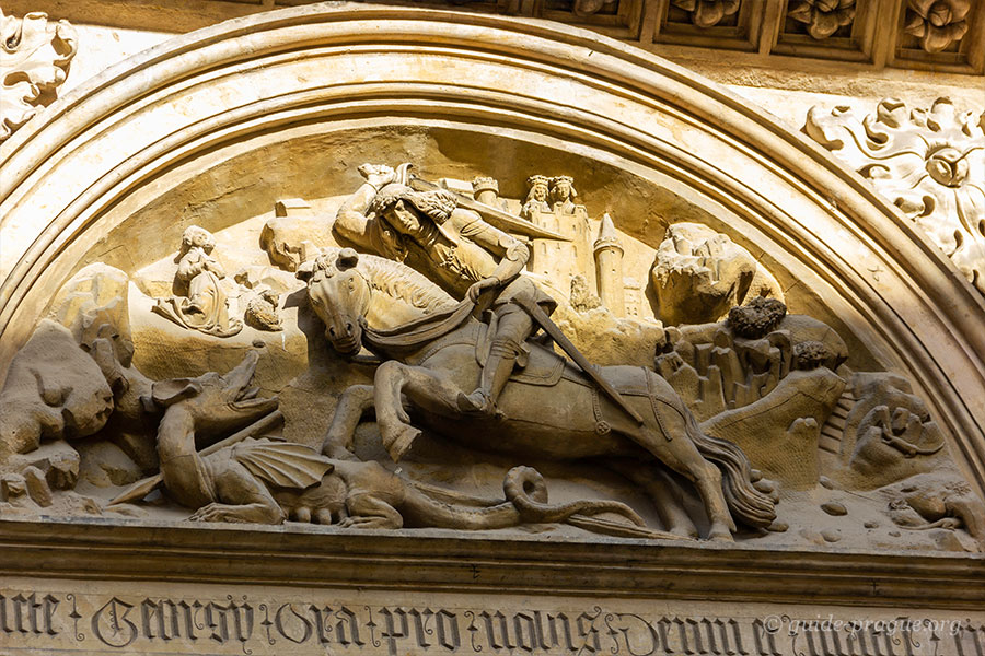 Detailed stone relief depicting St. George slaying the dragon, located at St. George's Basilica in Prague Castle.