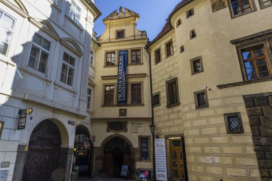 The historic House of Golden Ring in Prague, home to the City of Prague Museum, with its distinct medieval architecture and banners welcoming visitors to explore its exhibitions.