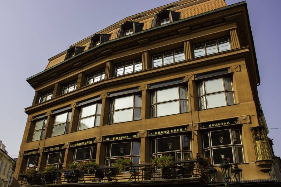 The iconic House of the Black Madonna in Prague, showcasing its unique Cubist architecture, with large windows and a terrace belonging to the famous Café Orient on the second floor.